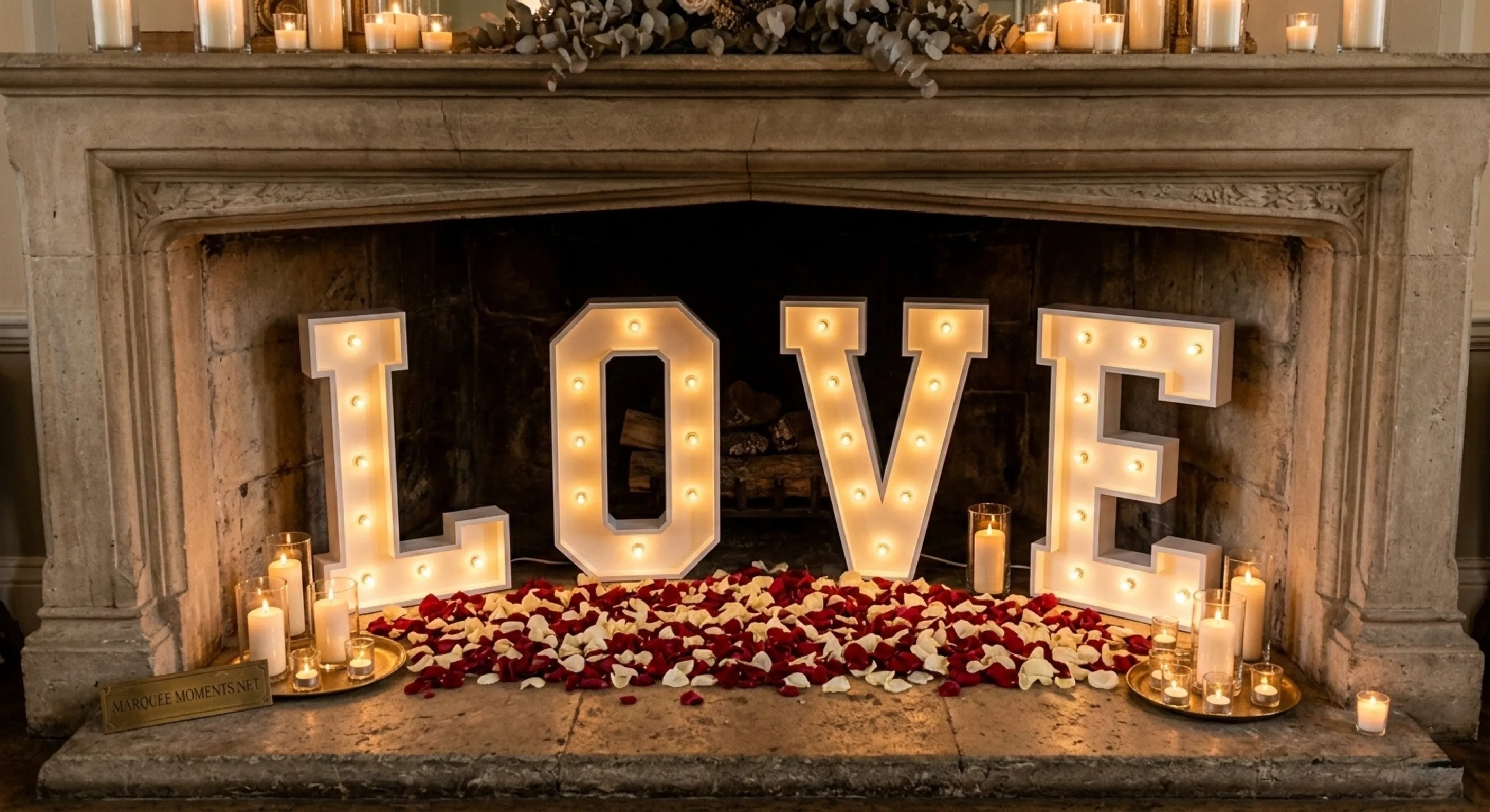 Extra large 4ft LOVE marquee letters glowing in front of a wedding venue fireplace