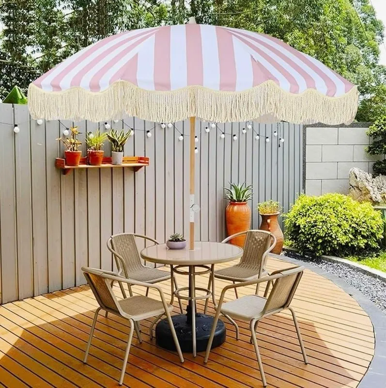Signature pink striped fringe umbrellas providing stylish shade for a summer event